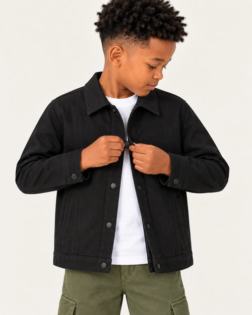 Aombe boys' black cotton twill jacket being snapped closed over a white T-shirt, waist-up view