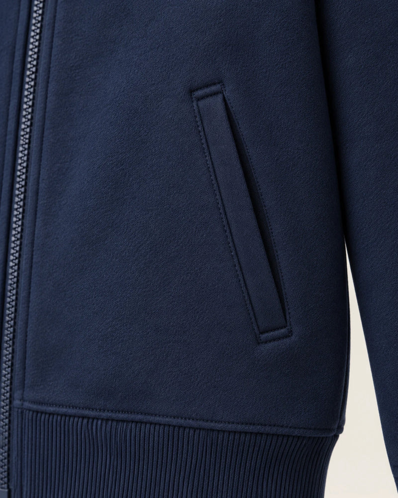 Close-up of a slash side pocket on the navy Aombe Sweat Jacket, showing the bar-tacked opening