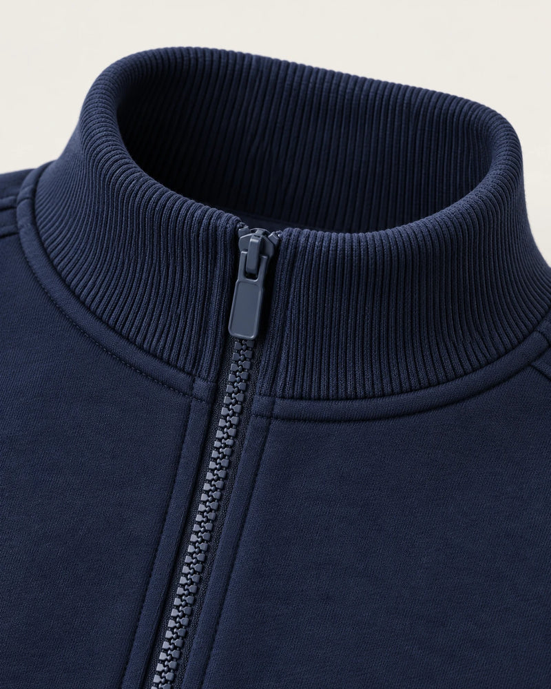 Close-up of the ribbed stand collar on the navy Aombe Sweat Jacket where it meets the zipper